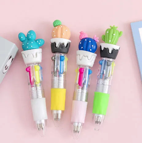 Cute cartoon four-colour press ballpoint pen with silicone grip and 0.7mm tip on a notepad.