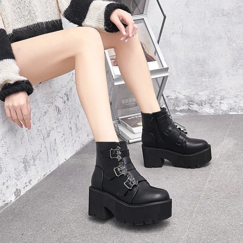 Black women's punk-style Martin ankle boots with a bat-shaped buckle and side zipper.
