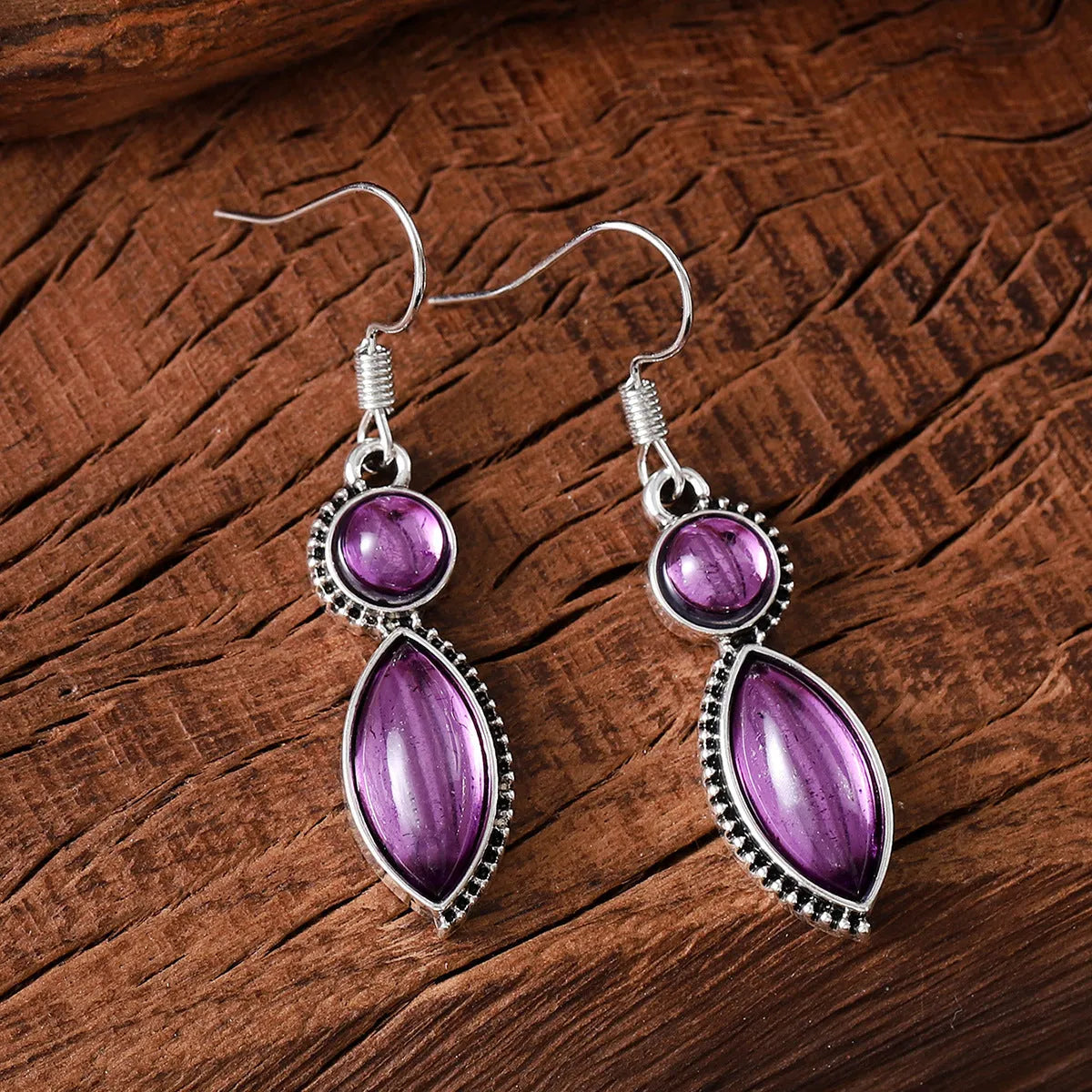 A pair of geometric vintage pendant earrings in black and purple colours with a bohemian style.