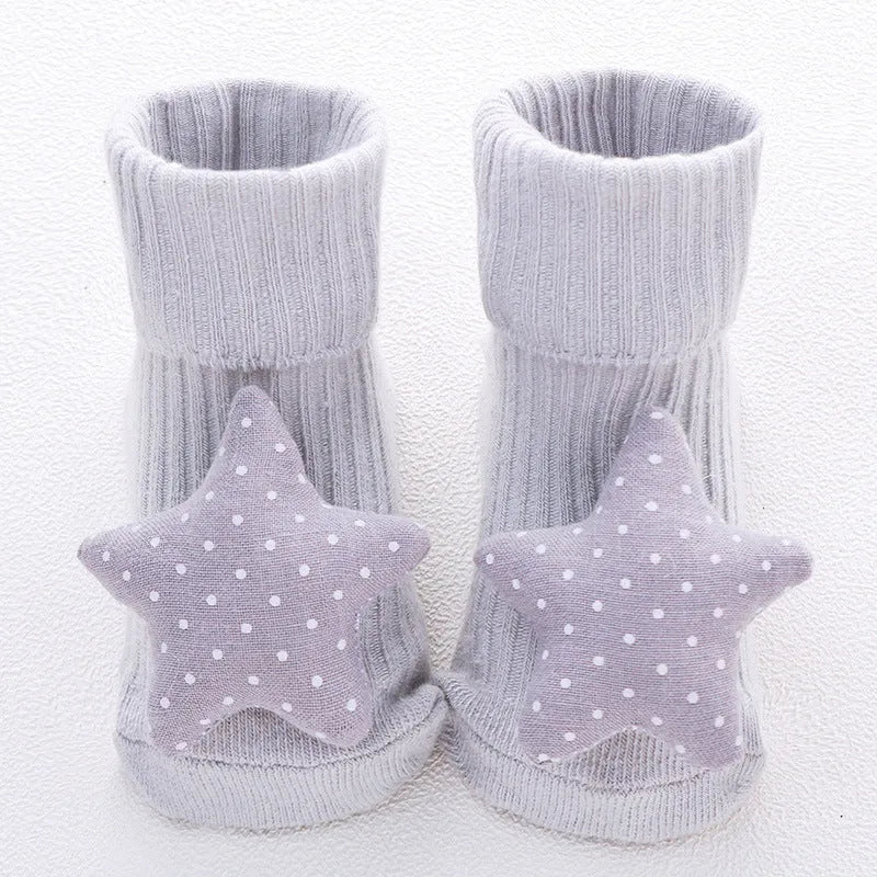 Cotton baby socks in multiple colours and prints including panda, lion, bows, and stars on a white background.