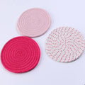 Set of three round grey cotton cord coasters, each 18 cm in diameter, on a wooden table.