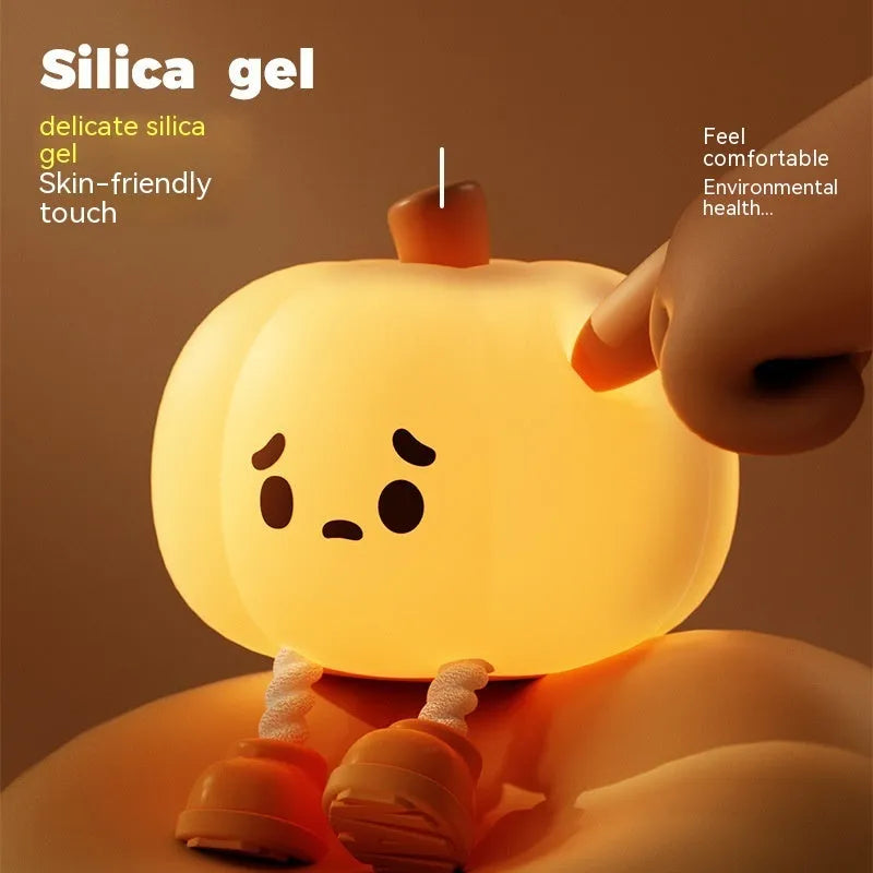 Pumpkin-shaped small night lamp in orange silicone with racket style design on table