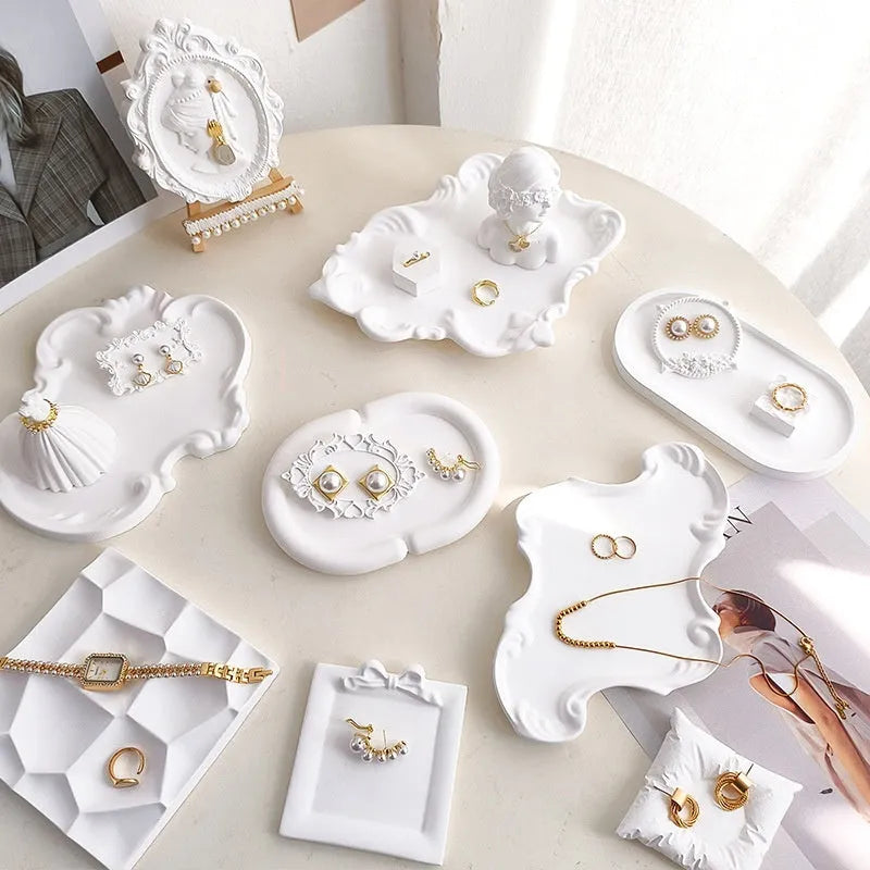European Baroque style gypsum jewellery display plate with rings and earrings on a dressing table