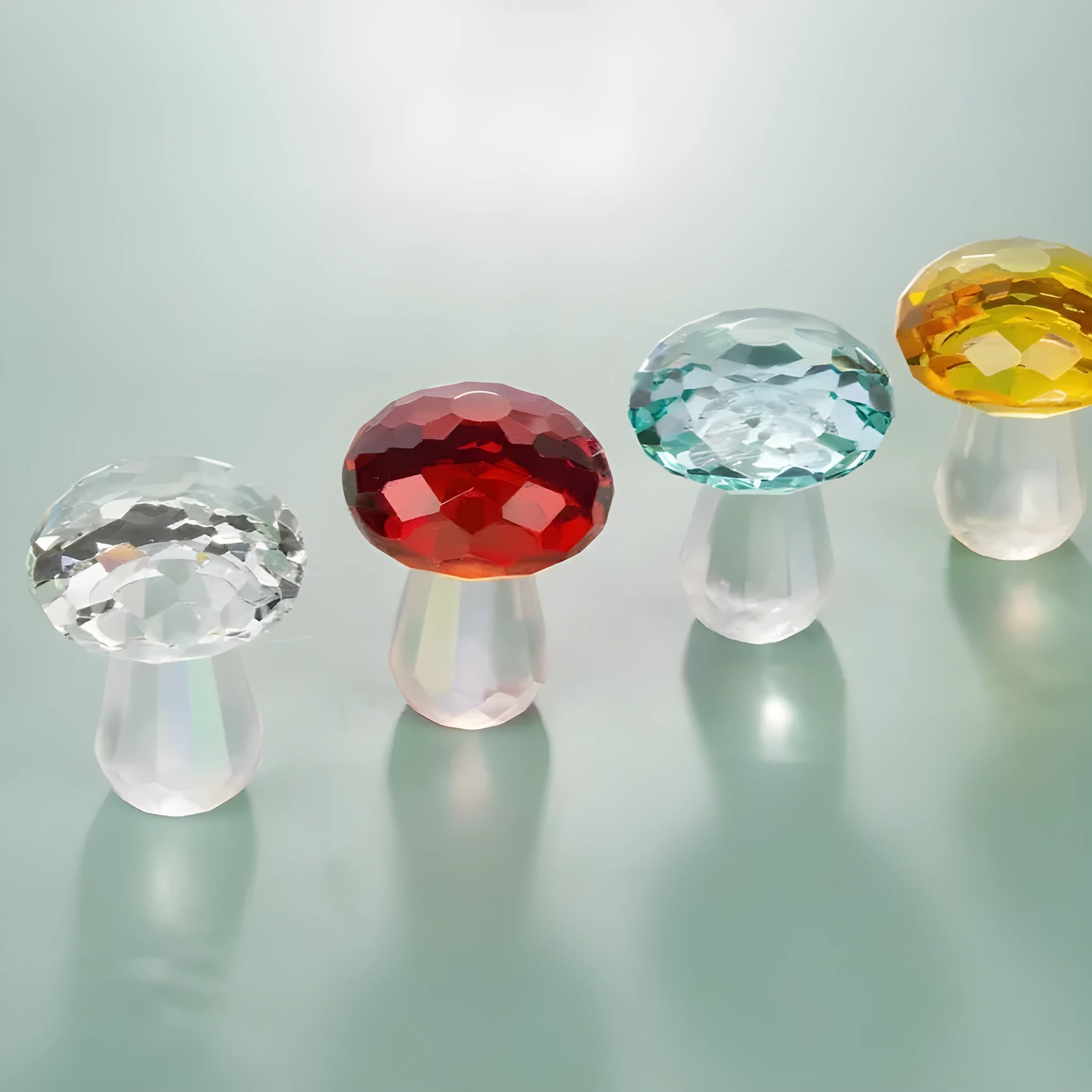 A set of colourful crystal mushroom decorations in transparent, green, red, and yellow on a white surface.