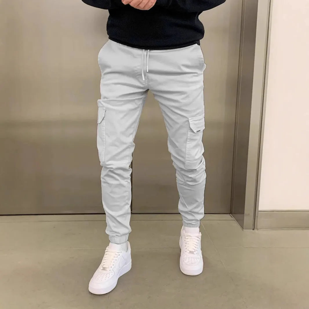 Men's casual straight-leg trousers with patch pockets in polyester fabric, available in seven colours with elastic waistband