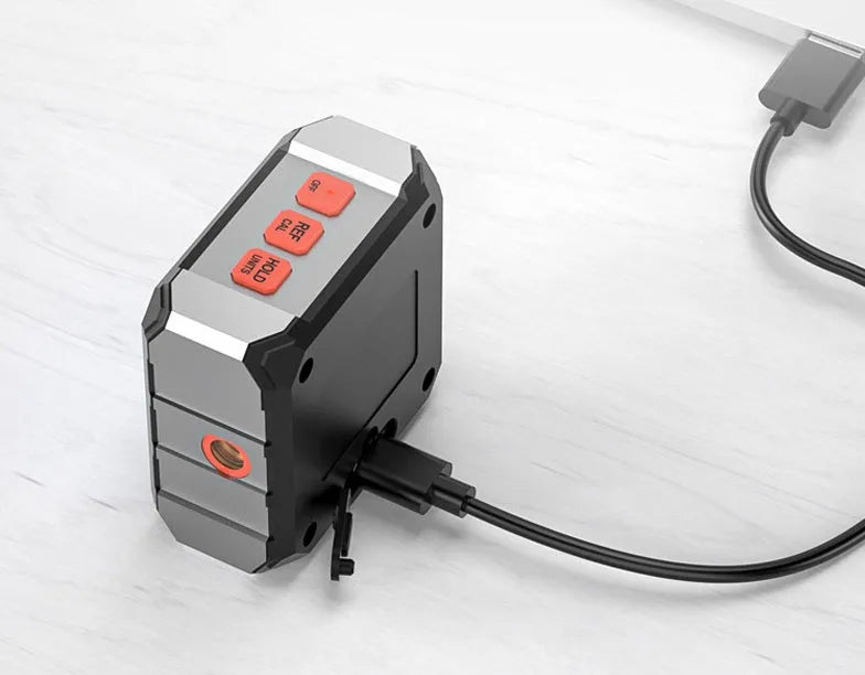Digital laser infrared inclinometer with alloy casing and backlit display on a metal surface.