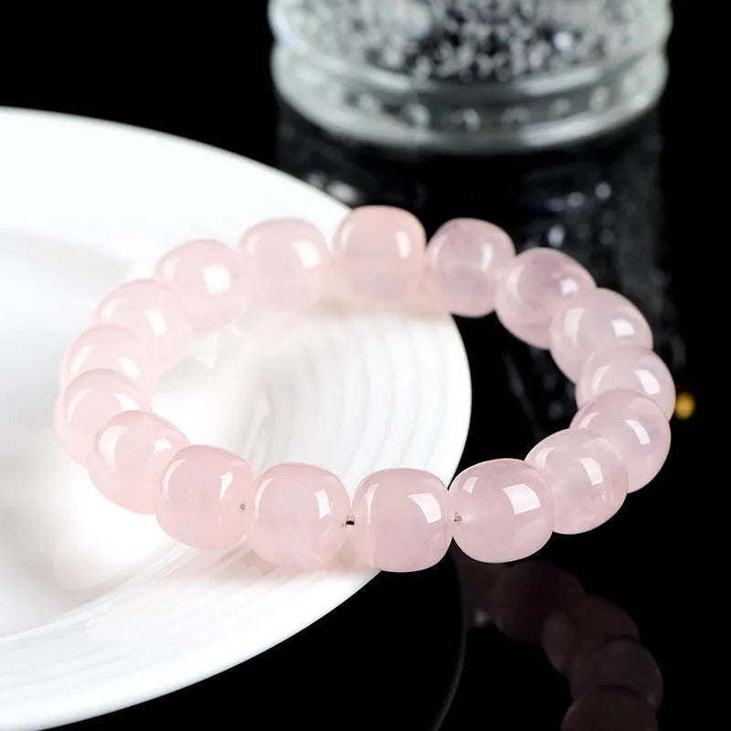 Pink natural bamboo crystal bracelet with 11-12mm geometric barrel beads on a wrist.