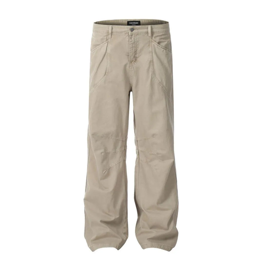 Men's loose straight-leg cotton trousers in brown, showing high waist and zipper fly.