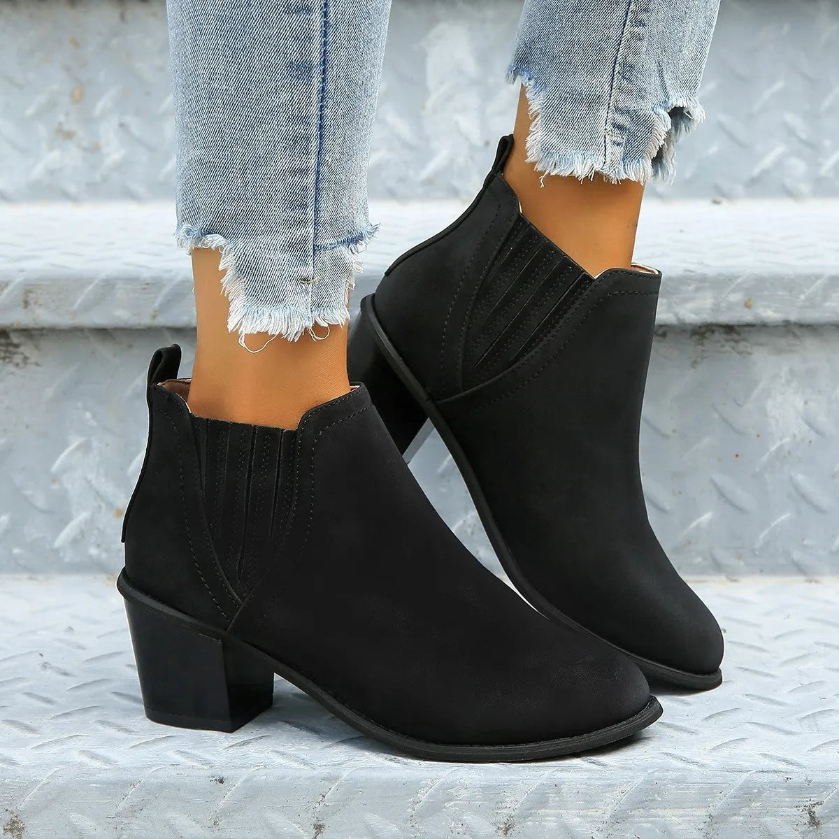 Women's black ankle boots with pointed toe and thick square heel on a rubber sole