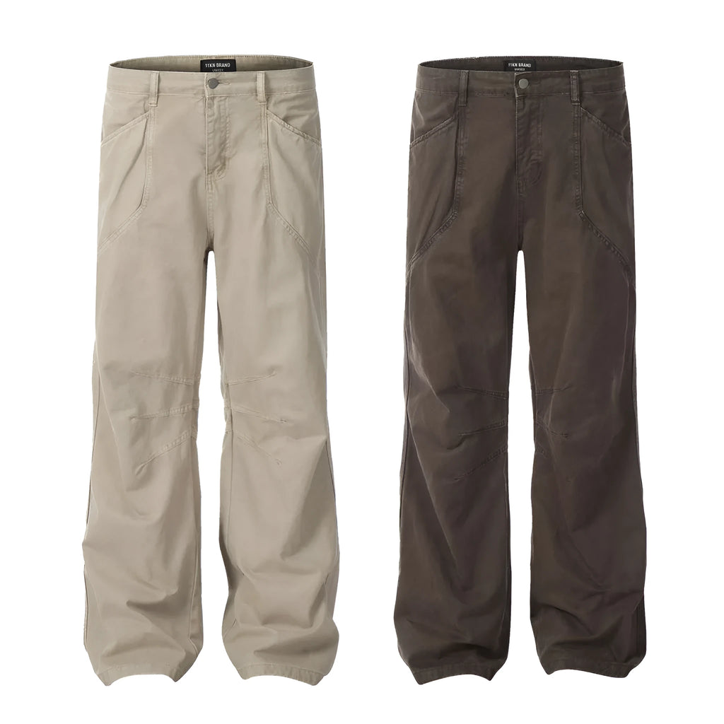 Men's loose straight-leg cotton trousers in brown, showing high waist and zipper fly.