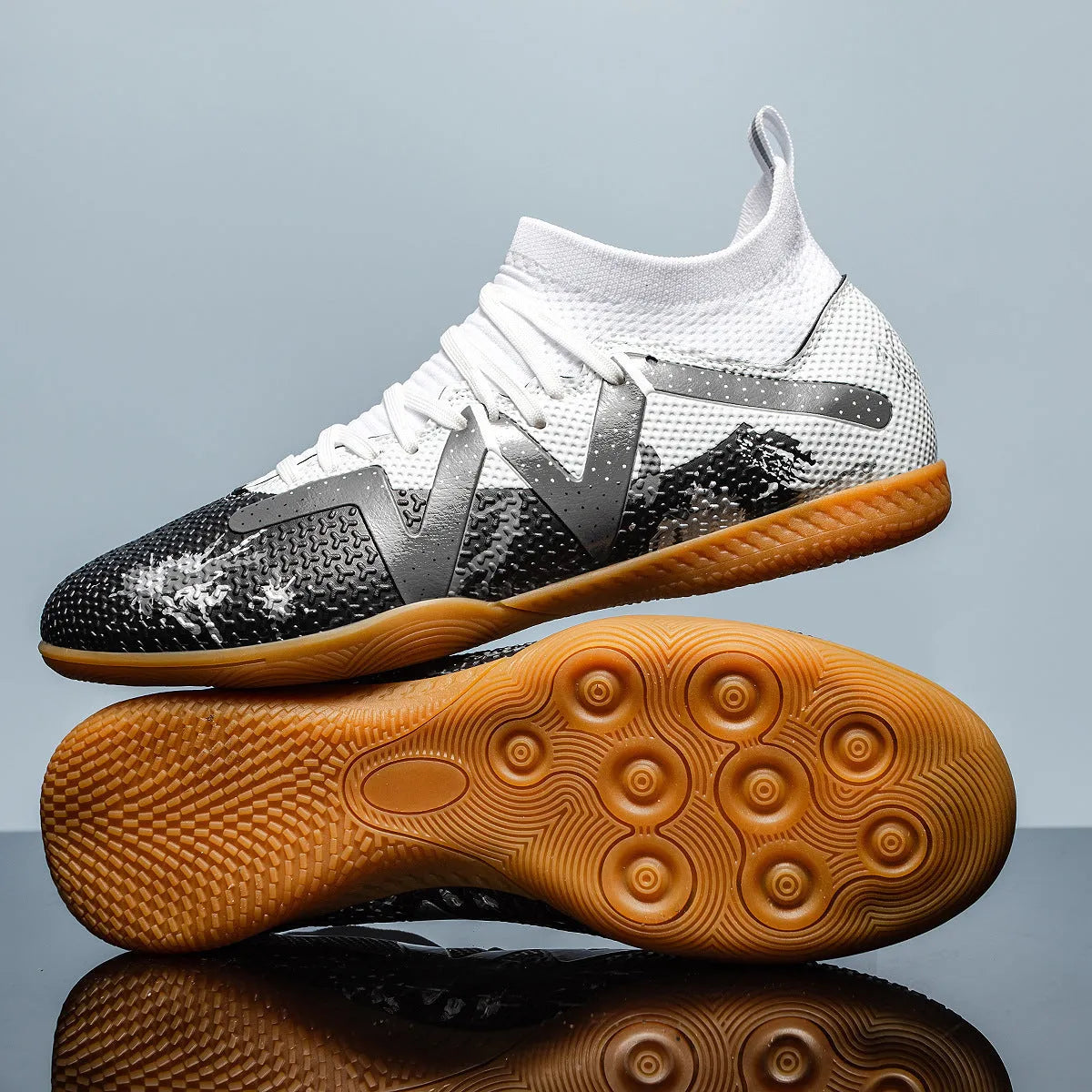 Adult low-top soccer shoes in black and yellow, showing studded rubber sole and printed PVC upper.