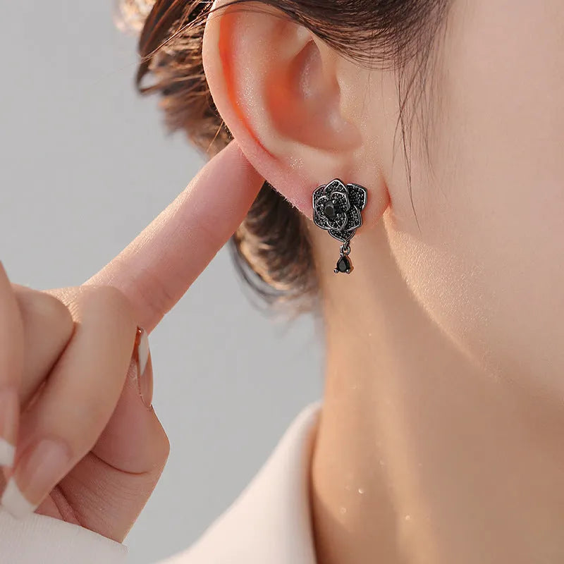Pair of black rose zircon floral stud earrings with an 18K gold electroplated finish on copper.
