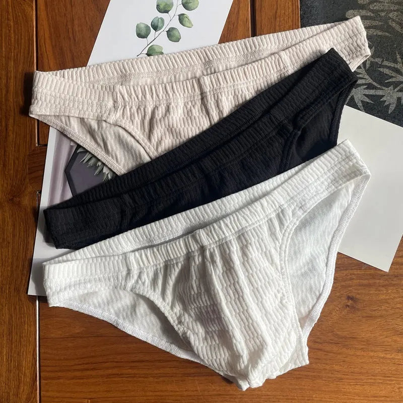Men's solid colour cotton triangle briefs in apricot, shown from the front on a mid-waist fit model.