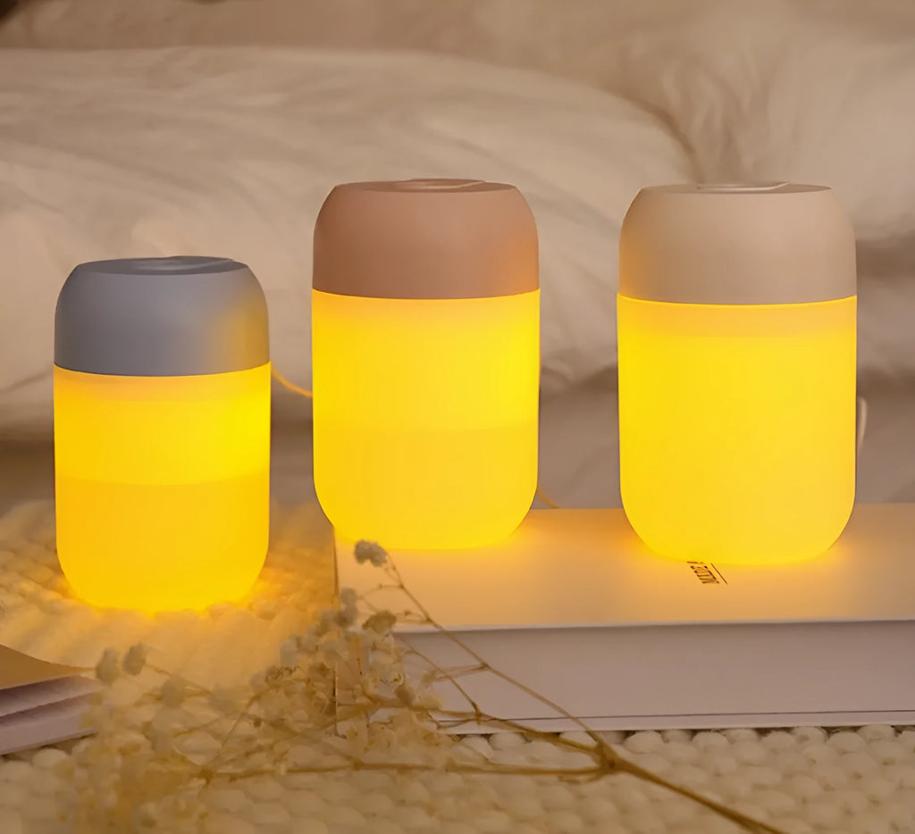 White cylindrical USB mini humidifier on desk with charging cable
