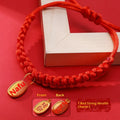 Adjustable hand-woven red rope pet collar with alloy lucky charm on wooden surface