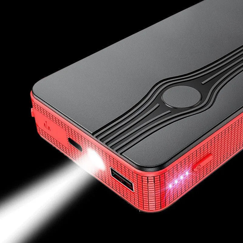 Red K4-E car jump starter power bank with display, shown next to a data cable on a dark surface.