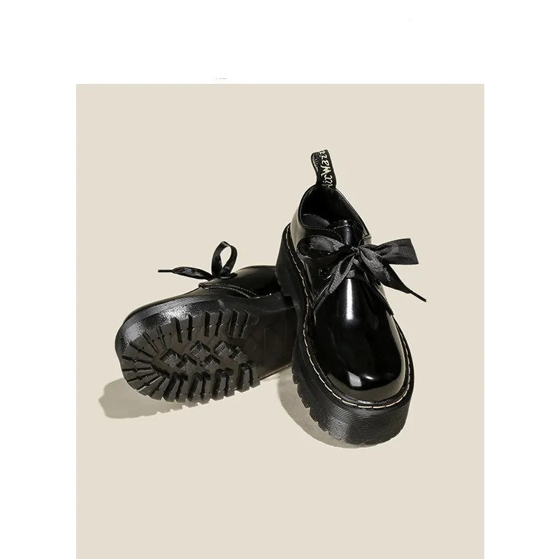 Women's white and black thick soled leather shoes with cross strap and ribbon detail on a superfine fibre upper.