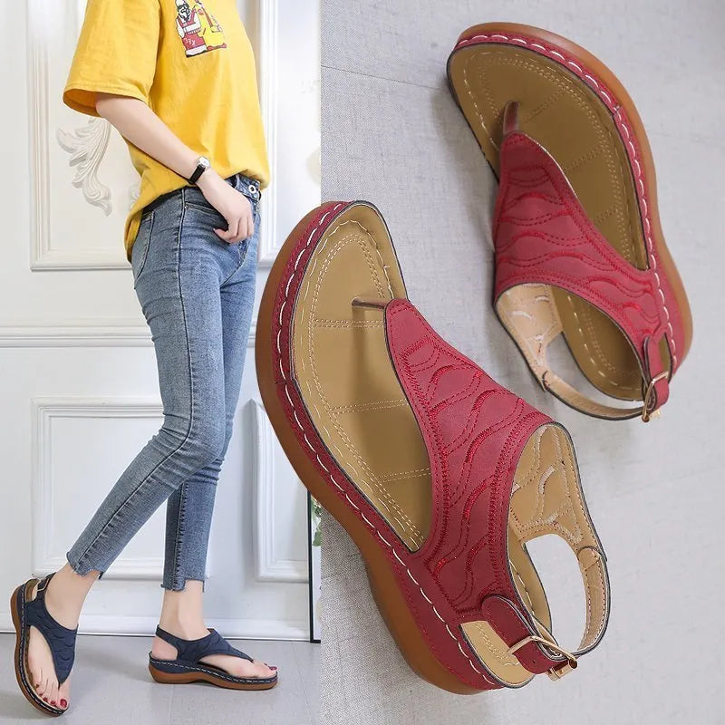 Women's wedge heel flip flop sandals in black with an adjustable buckle strap on the back.