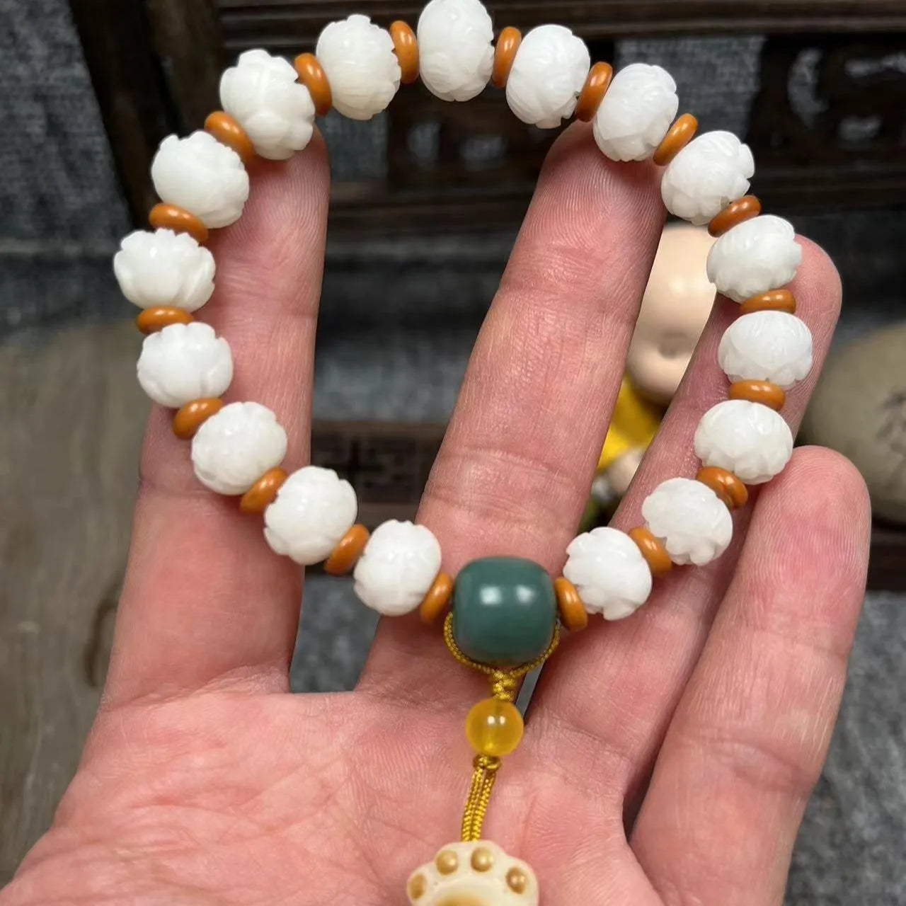 Carved Bodhi root bracelet with white jade, lotus, and pumpkin beads in various sizes.