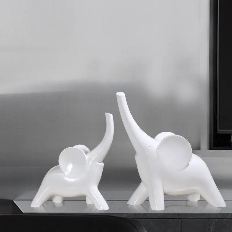 Modern minimalist solid resin elephant ornament in rose gold or white finish on a shelf.