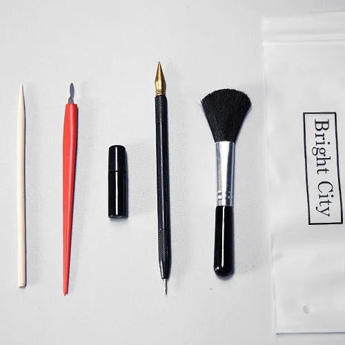Scratch painting tool set with healing pens, brushes, scrapers, and photo frames on white card paper