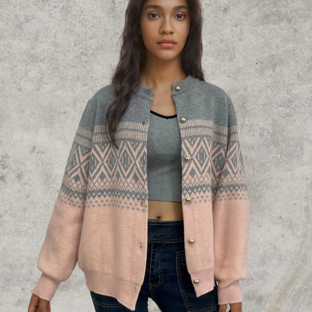 Woman wearing a grey diamond knit cardigan with contrast colour panels, long sleeves.