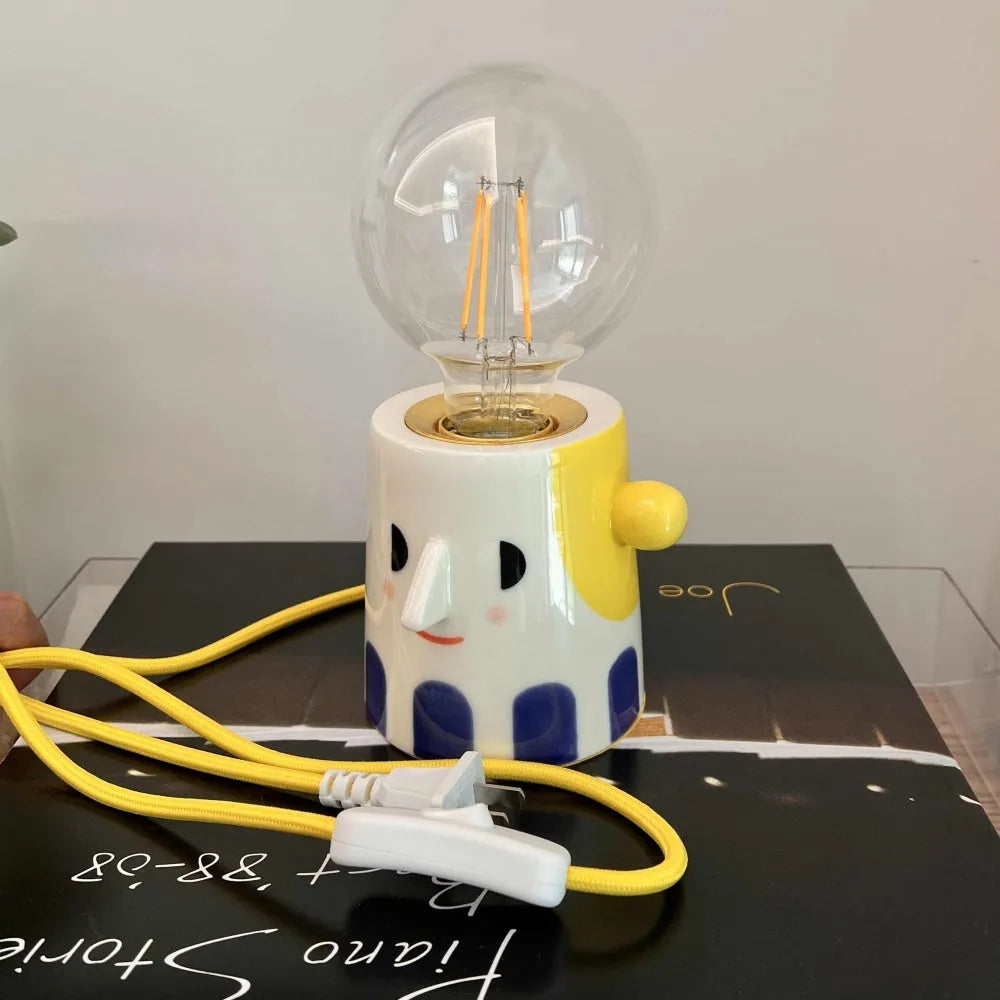 Handmade ceramic table lamp with a spherical ball headlight shade on a ceramic base.
