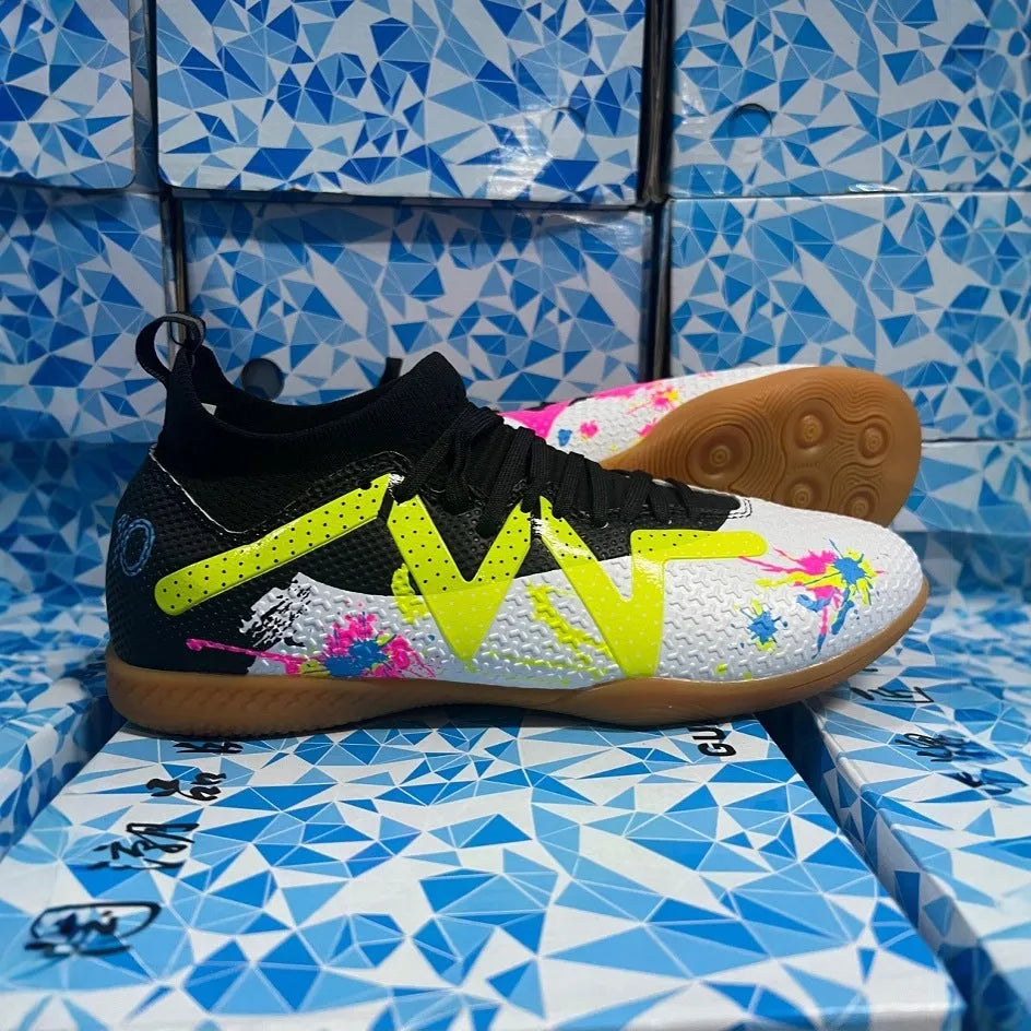Adult low-top soccer shoes in black and yellow, showing studded rubber sole and printed PVC upper.