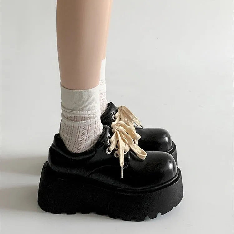 Women's matte black retro platform shoes with chunky rubber sole and lace-up buckle.