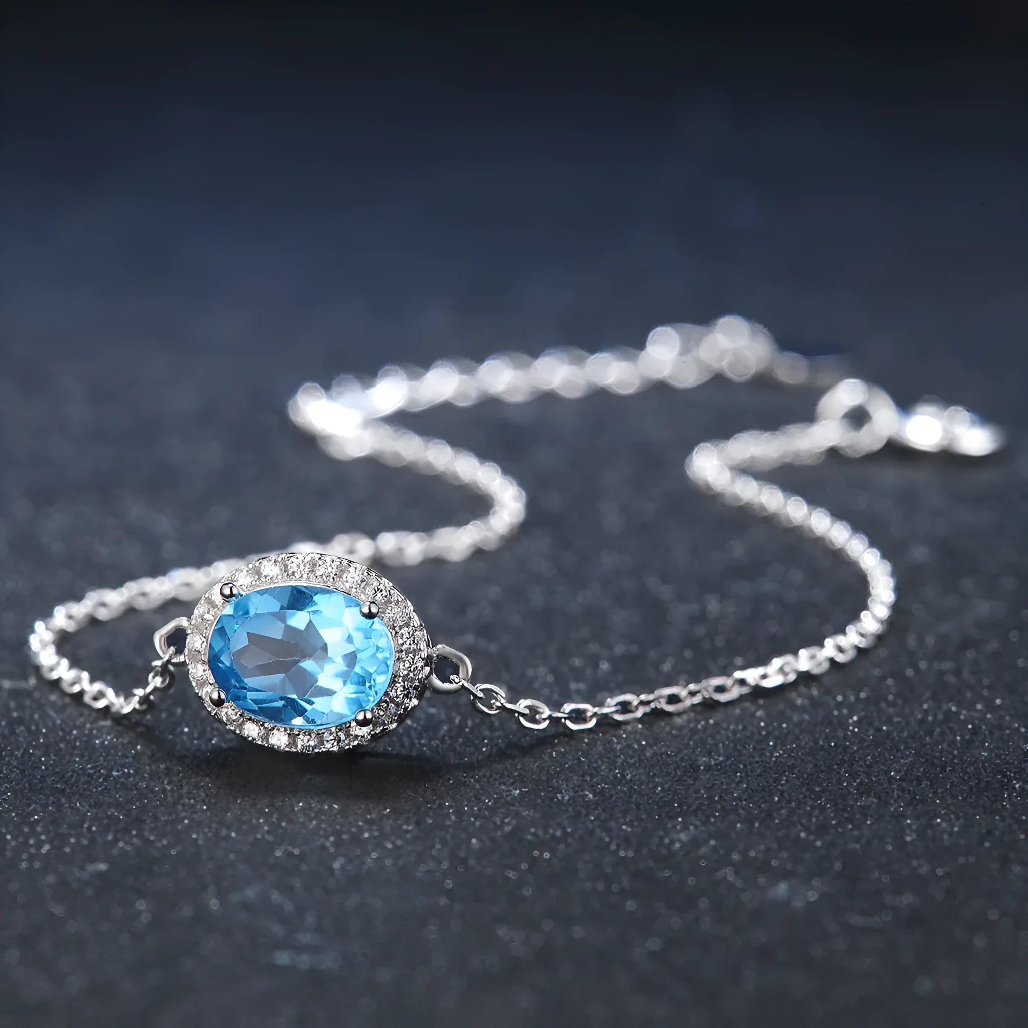 Geometric blue topaz and sterling silver four-piece jewellery set with earrings, ring, pendant, and necklace.