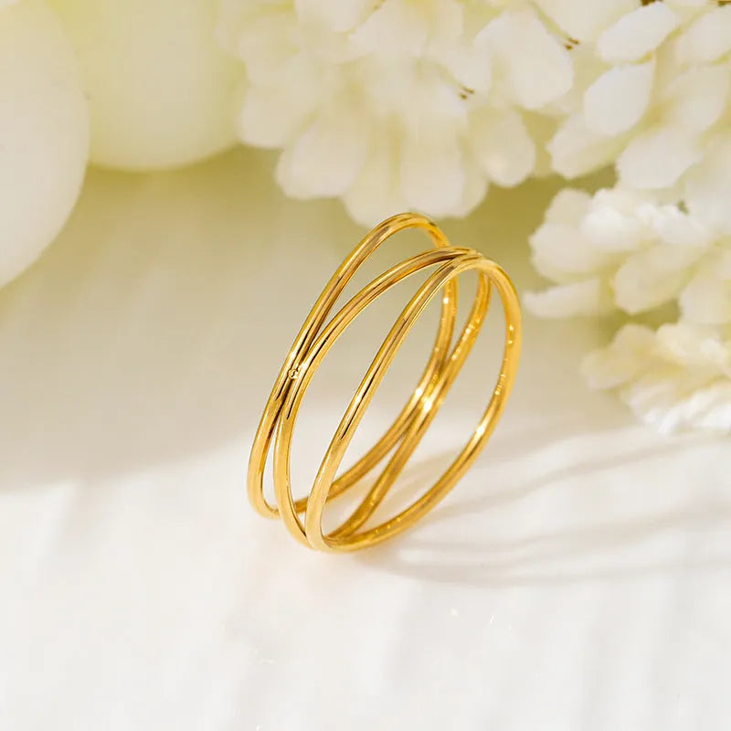 Gold-coloured geometric line ring with three-layer coil design on titanium steel band