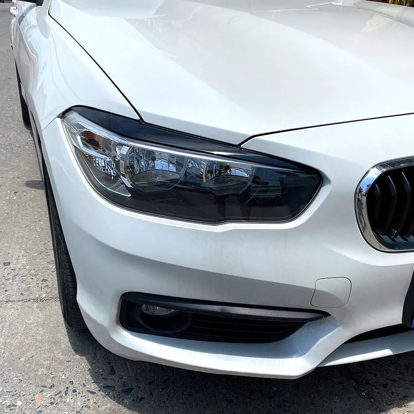 Pair of ABS headlight eyebrow stickers for BMW 1 Series F20, piano black finish, 48x8x8 cm