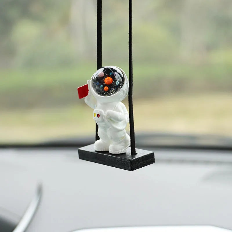 Resin astronaut car pendant showing five cartoon designs including telescope and flag-holding astronauts