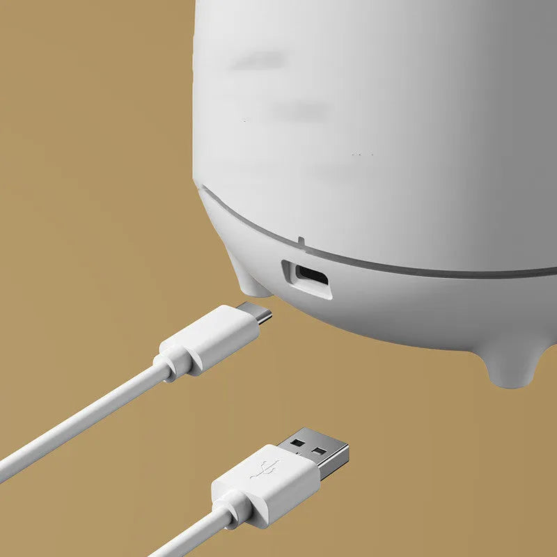 Volcano-shaped white humidifier with USB cable and mist rising from top
