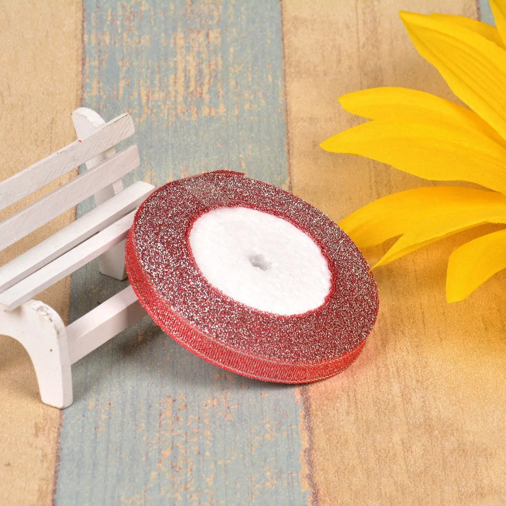 Spool of green onion patterned ribbon in gold silk and silver polyester on a 3-point reel.