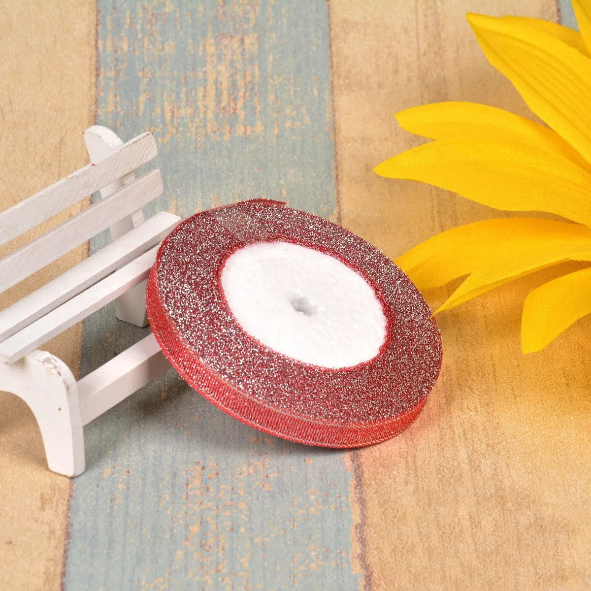 Spool of green onion patterned ribbon in gold silk and silver polyester on a 3-point reel.