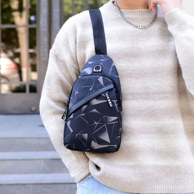 Men's blue Oxford cloth crossbody sling bag showing earphone hole and front zipper.