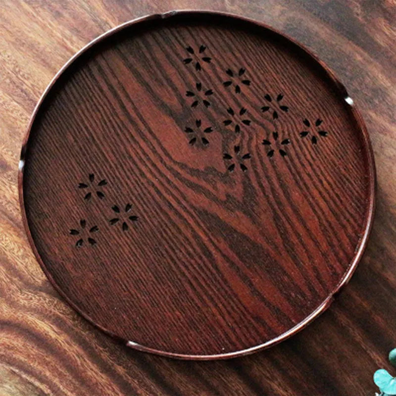 Twelve wooden dessert plates with hollow cherry blossom pattern arranged in set