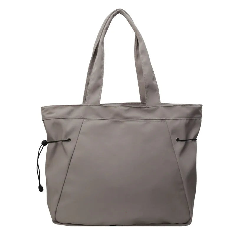 A foldable Oxford cloth commuter shoulder tote bag shown in one of five colours: black, brown, dark gray, light gray, or purple.