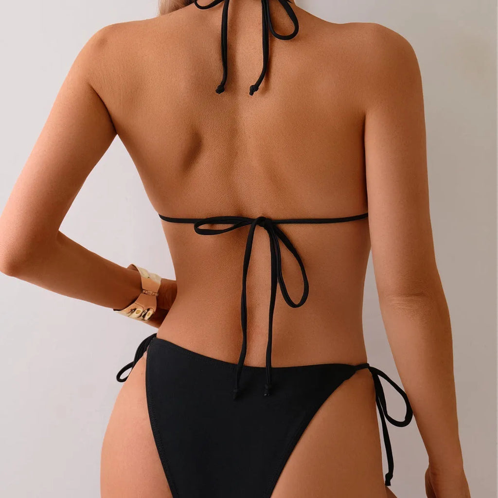 Black women's bikini swimsuit with metal bead detail on the split design.