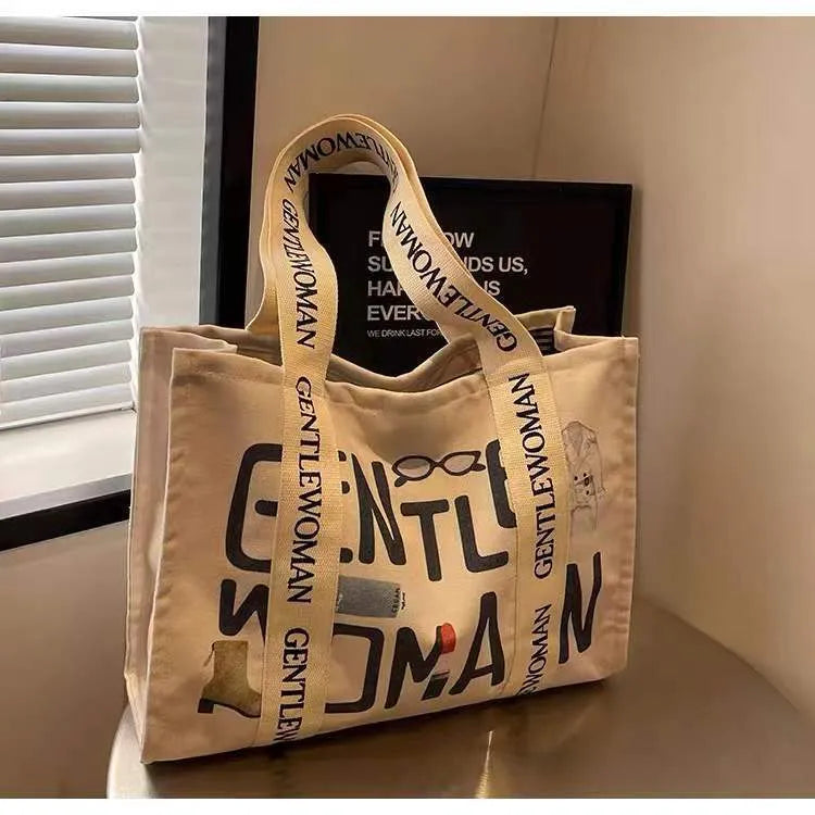 Large canvas tote bag with printed design, featuring two fabric handles, shown in available colour style options.