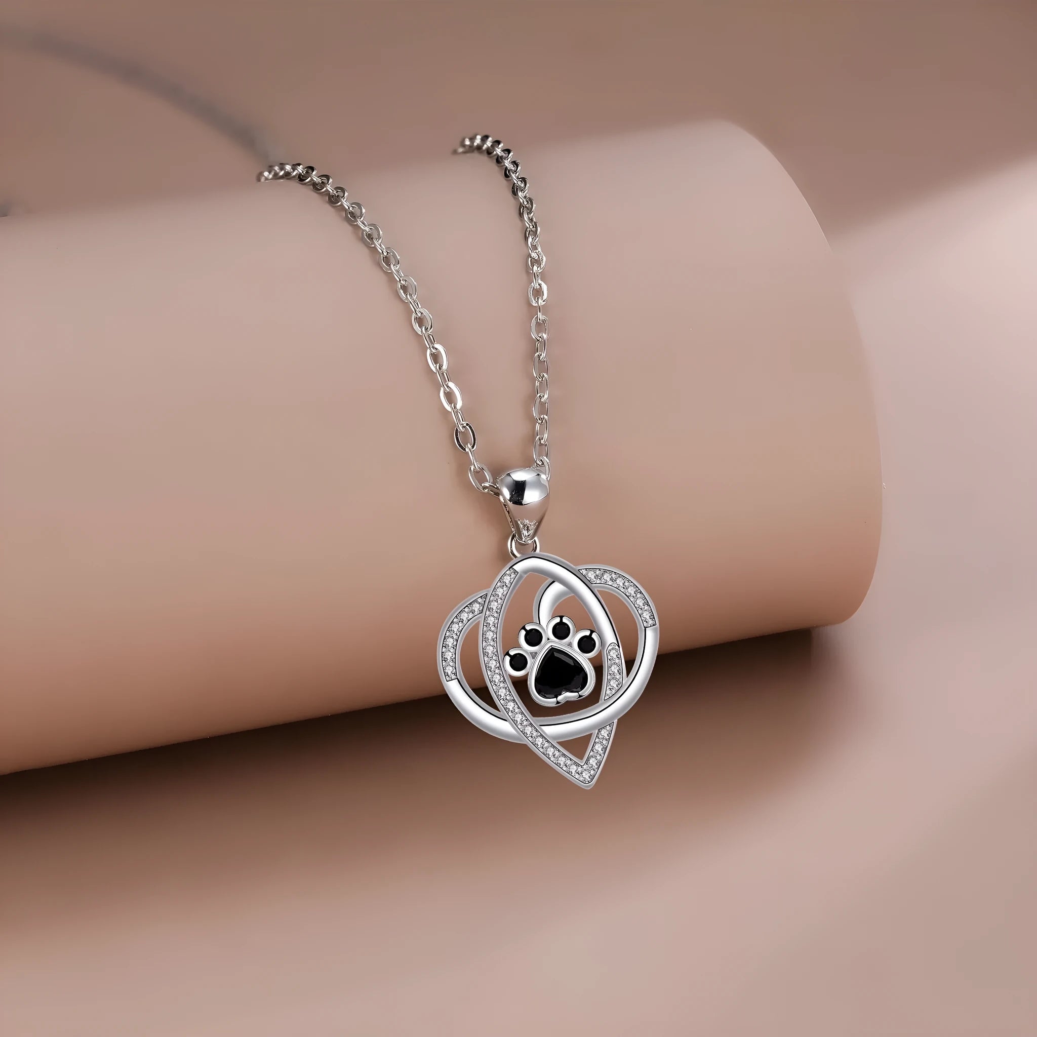 Copper necklace for women showing a pendant with dog paw and cat footprints design on a cross chain.