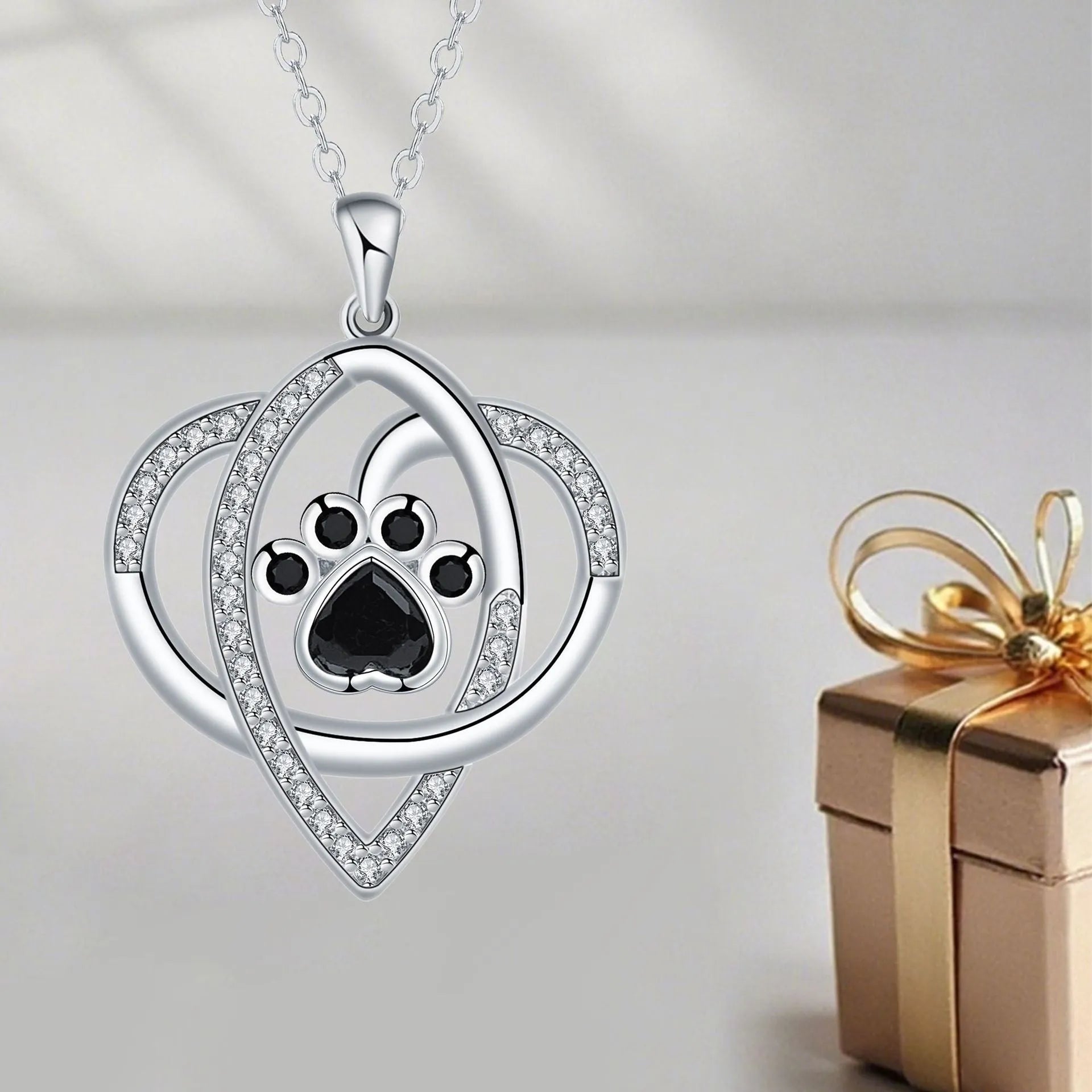 Copper necklace for women showing a pendant with dog paw and cat footprints design on a cross chain.