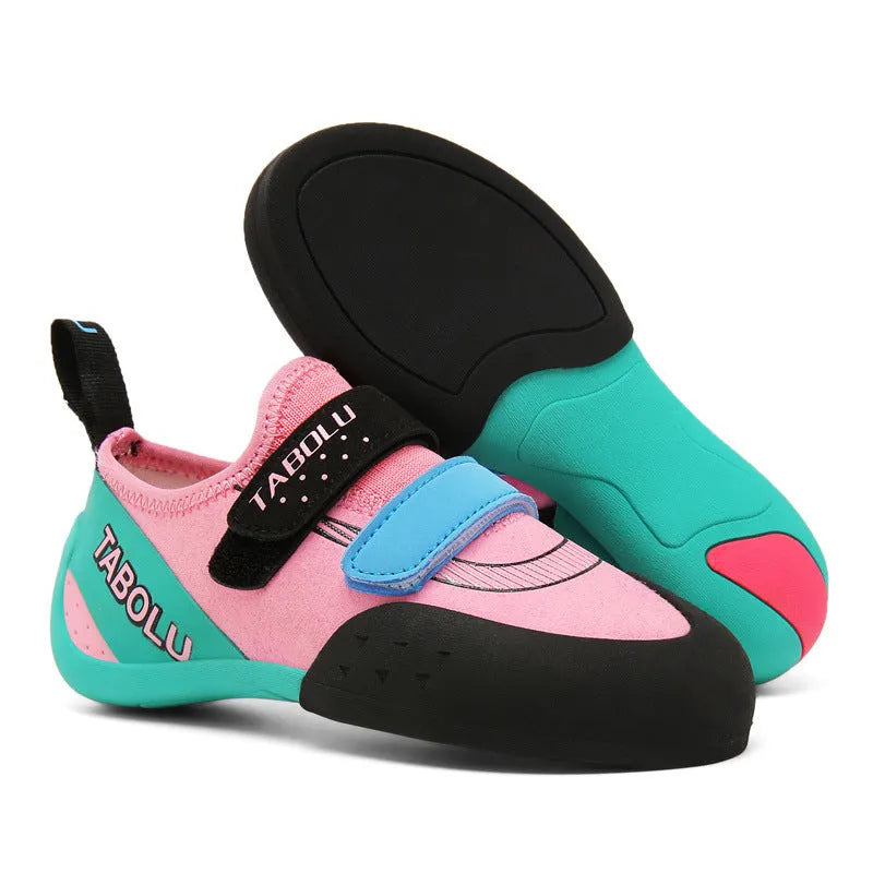 Beginner rock climbing shoes with Velcro straps and a coloured rubber sole on a climbing hold.