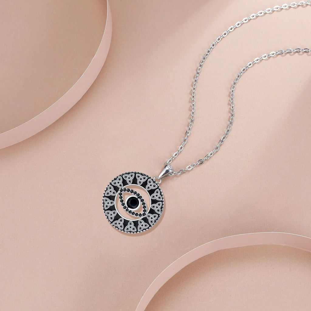 Close-up of a copper Devil's Eye pendant necklace with an electroplated finish on a matching cross chain.