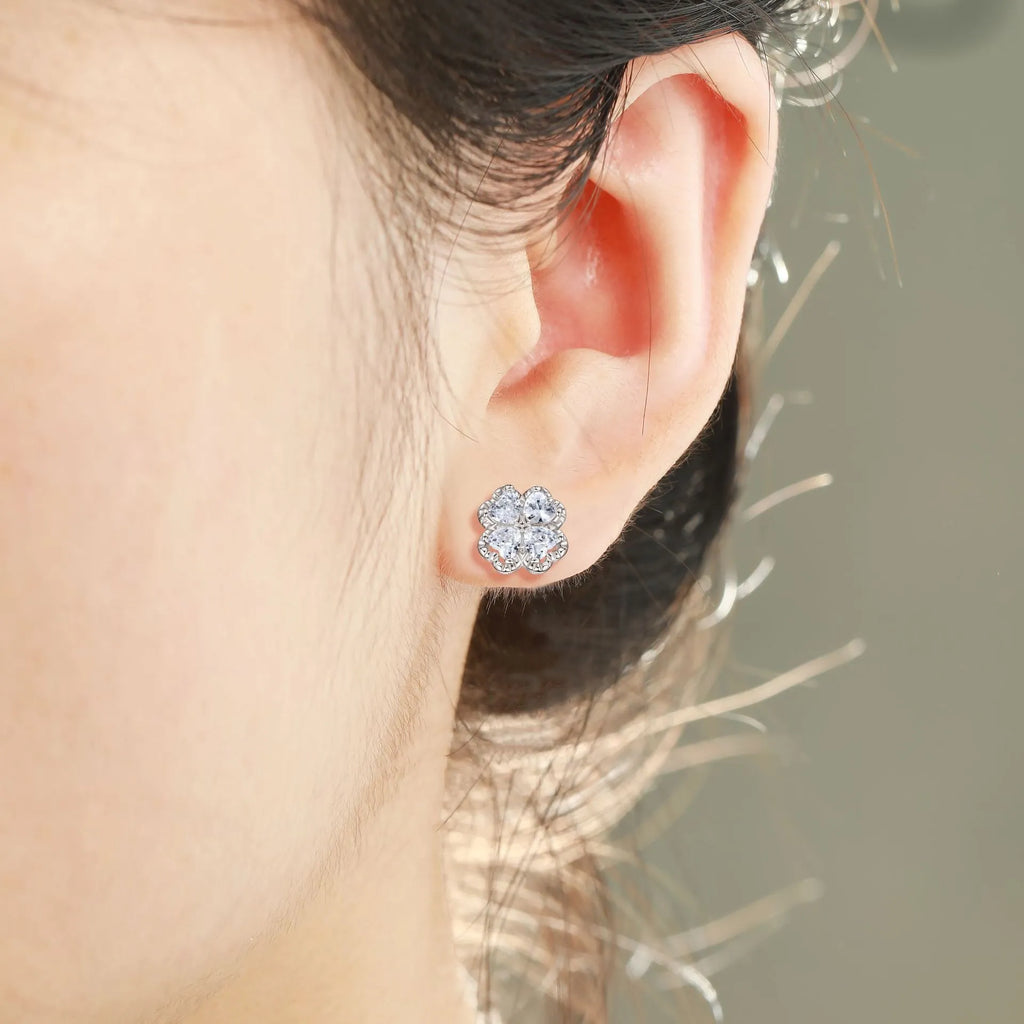 Pair of heart-shaped silver earrings with a four-leaf clover design and zircon stones.