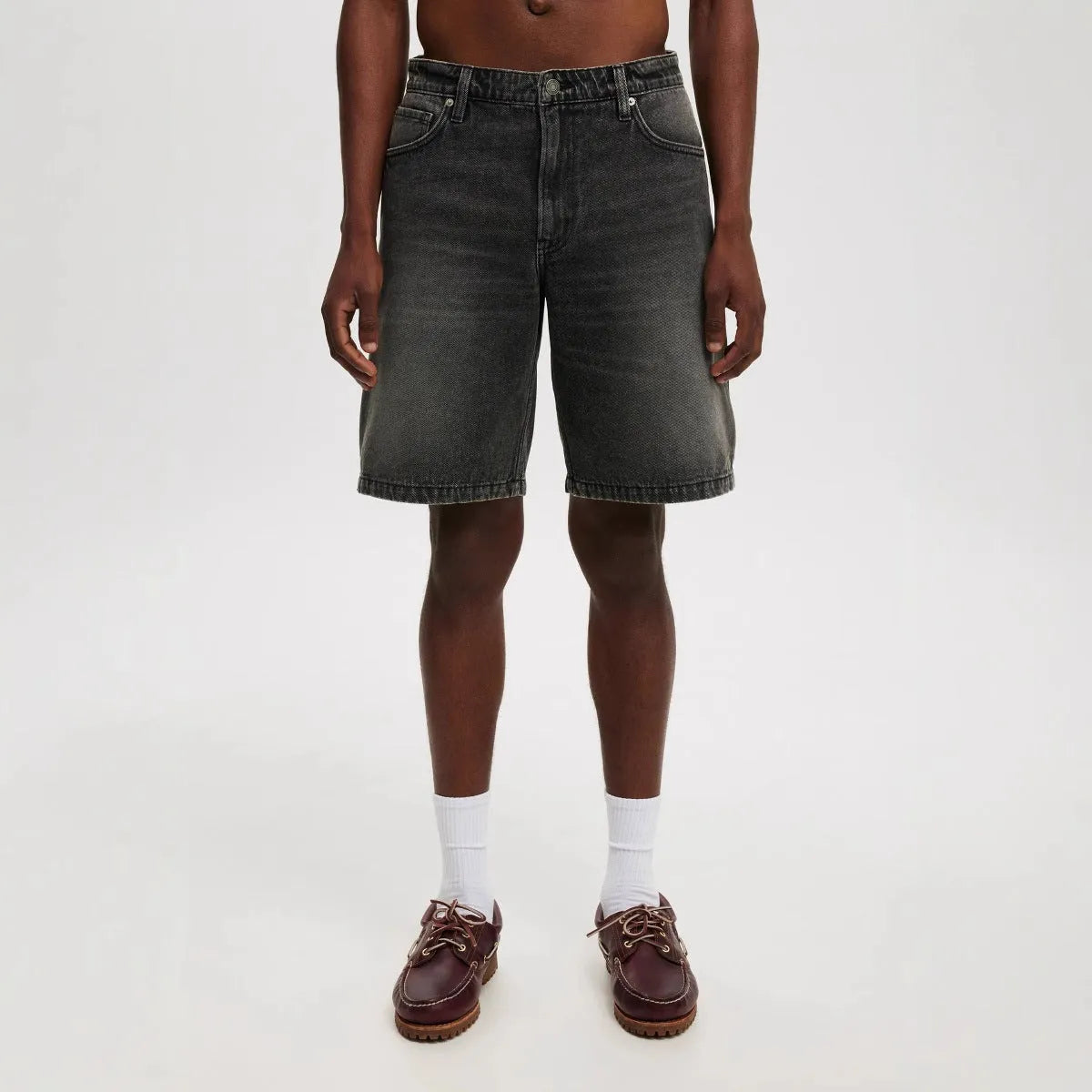 Men's loose fit light blue denim jeans with straight leg on a neutral background