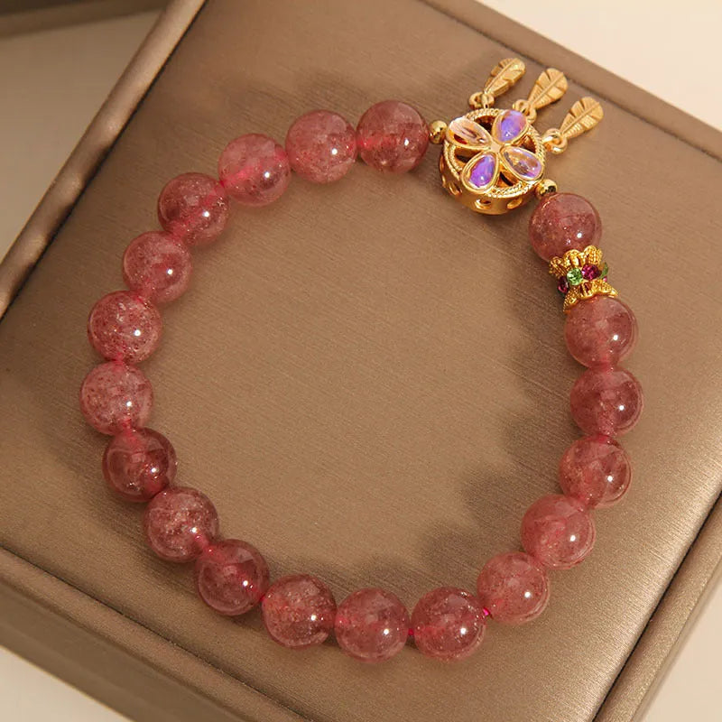 Women's strawberry quartz crystal bracelet with four leaf dream catcher pendant.