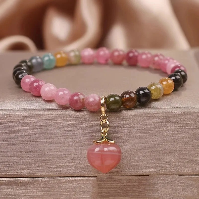 Natural rainbow tourmaline single-circle bracelet with agate peach pendant on wrist