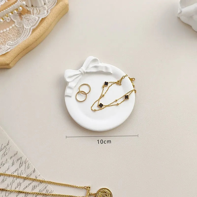 European Baroque style gypsum jewellery display plate with rings and earrings on a dressing table